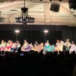 Dancers on the stage with flowy skirts.