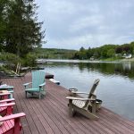 colorful chairs sitting on deck beside a lake