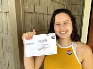 Holding up my mail in ballot and wearing an "I voted today" sticker. 