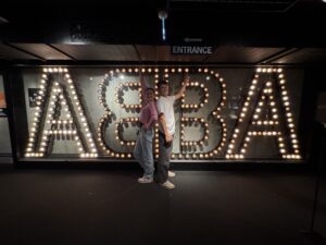 my brother and I standing in front of the ABBA sign at the museum