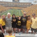 the family at the football game in front of kinnick field