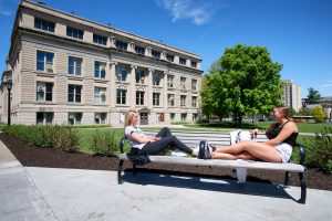 Students sitting on a bench on the Pentacrest