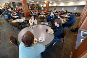 A group of students sitting together at dining table.