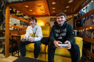 Two students holding a controller and laughing.