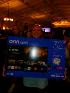 A photo of my friend holding up the TV she won at Bingo